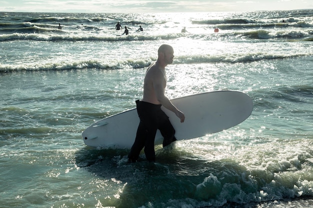 Surfer comes out of the sea