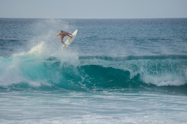 Surfer die een golf springt in Rocky Point op de Kust van het Noorden van Oahu, Hawaï, de VS