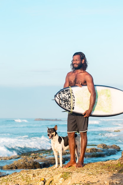 Photo the surfer is holding a surfboard on the indian ocean shore