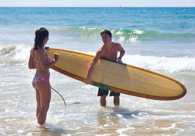 Surfer legt de theorie van surfen aan een jonge vrouw uit