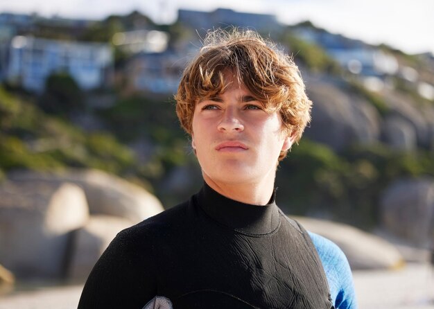 Surfer man en denken aan strandvakantie en ideeën voor wedstrijdtraining en weekendje weg Mannelijke man en atleet in badpak vakantie aan zee en oefenen voor sporthobby en zomervakantie