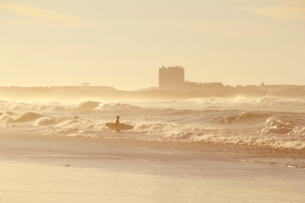 Surfer in ocean in sunset