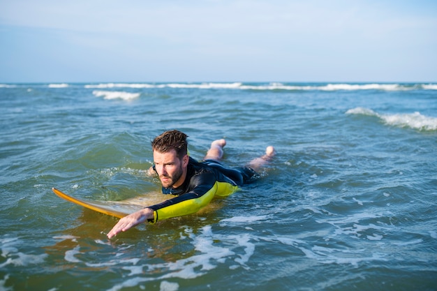 Surfer peddelen door het water