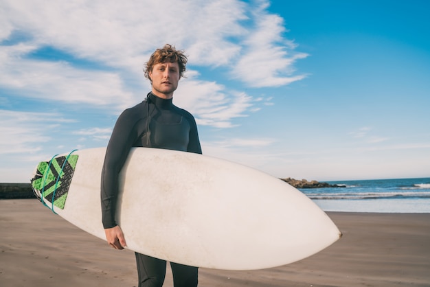 Surfer standing in the ocean with his surfboard