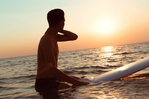 Un surfista al tramonto.