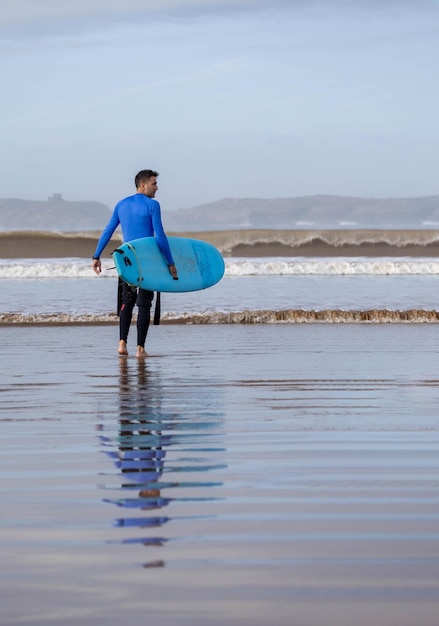 surfer with the board entering the water