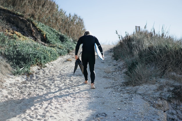 surfer with flippers and a bodyboard in a hydro suit on the ocean shore