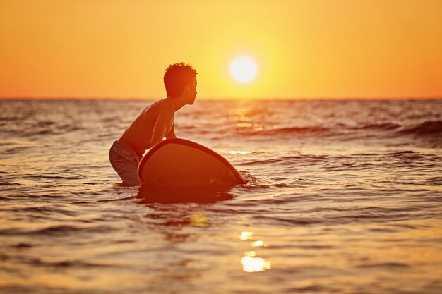 A surfer with his surfboard at the beach