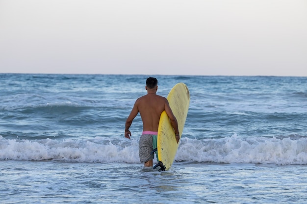 surfer with surfboard on the seashore