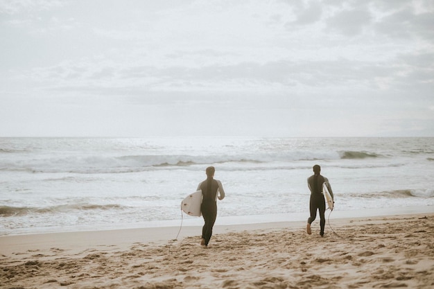 Surfers die op het strand rennen