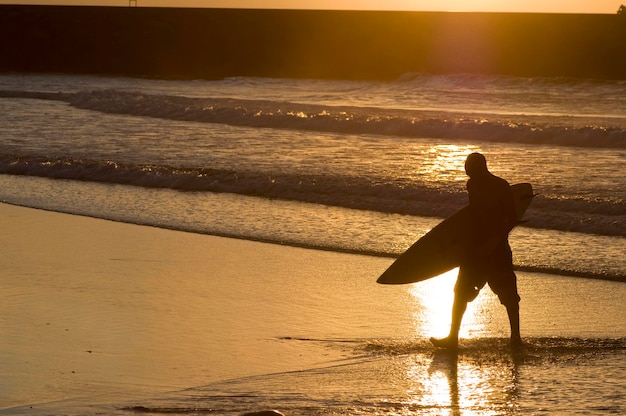 surfers in een kleurrijke zonsondergang in een kustgebied