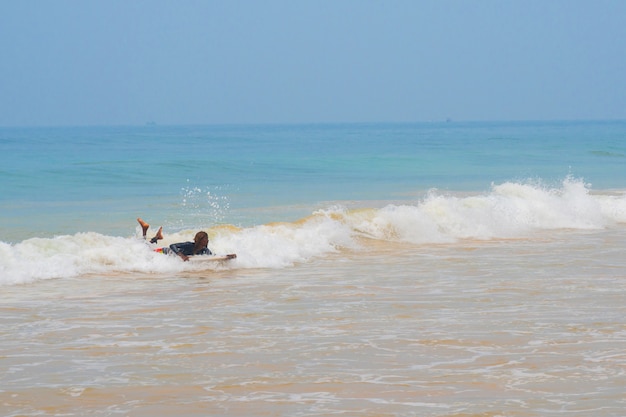 Surfers ride on a wave in the ocean.