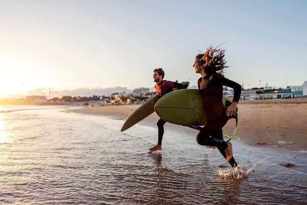 Surfers running into the water