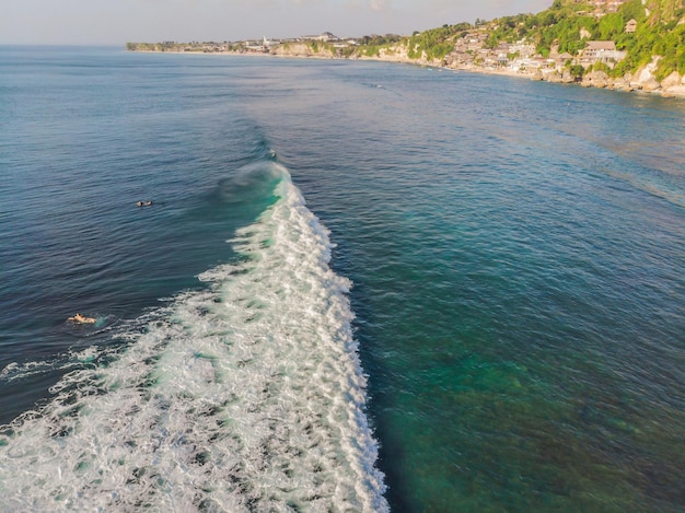 Surfers on the waves in the ocean, top view.