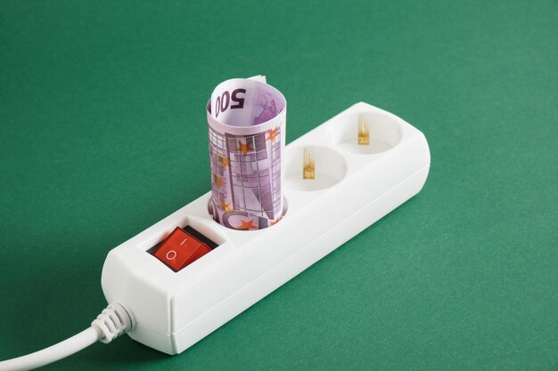 Surge protector and money on a green background electricity
bill concept electricity price increase