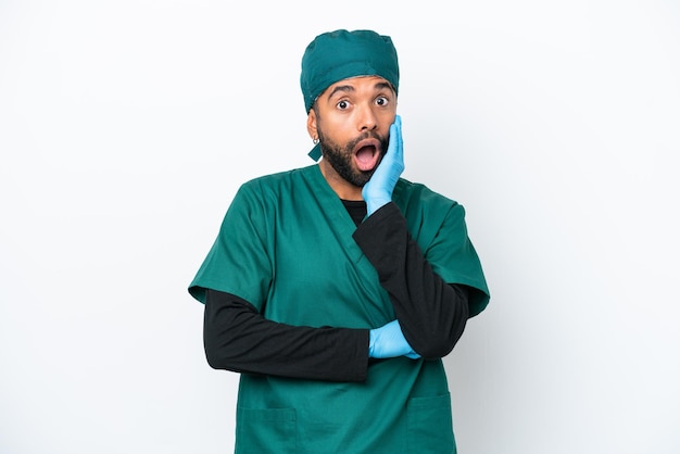 Surgeon Brazilian man in green uniform isolated on white background surprised and shocked while looking right