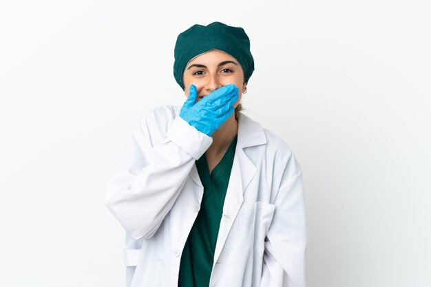 Surgeon caucasian woman isolated on white background happy and smiling covering mouth with hand