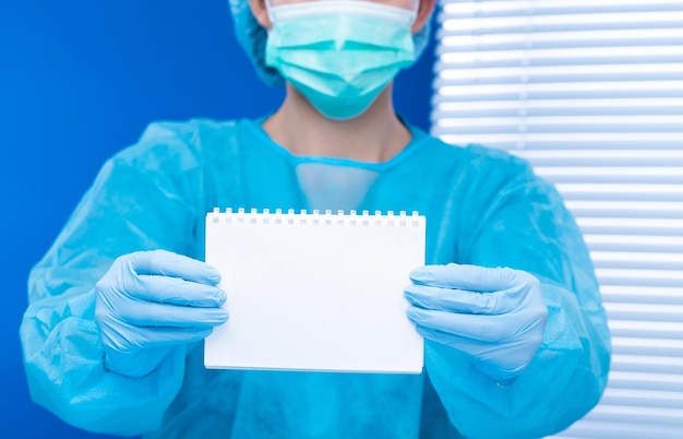 Врач-хирург держит пустой чистый бумажный документ медицинский работник носит синюю форменную перчаточную маску в больнице, чтобы показать ответственность, этическую мораль перед социальным как профессиональное пространство для копирования здравоохранения