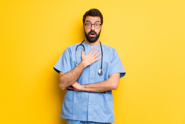 Surgeon doctor man surprised and shocked while looking right