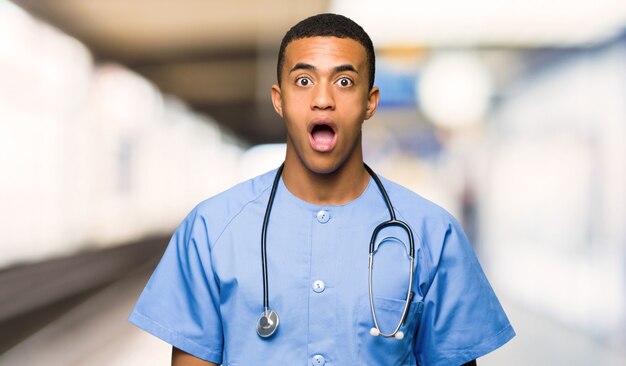 Surgeon doctor man with surprise and shocked facial expression in a hospital