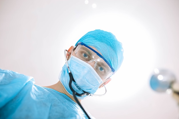 surgeon doctor in the operating room looking at the camera