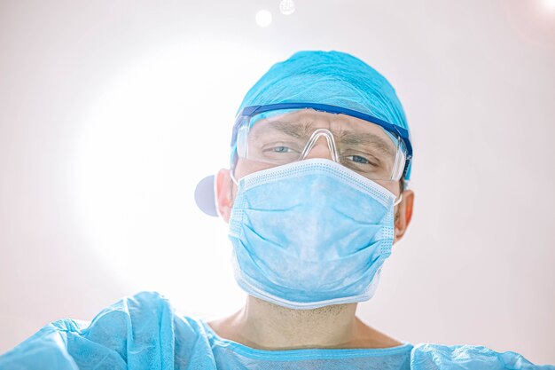 Surgeon doctor in the operating room looking at the camera