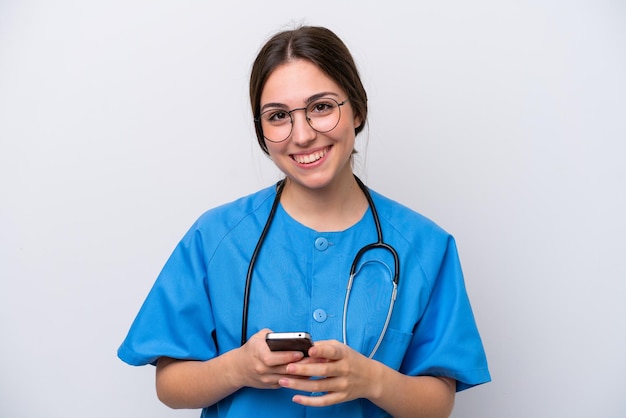 Женщина-врач-хирург держит инструменты на белом фоне, отправляя сообщение с мобильного телефона