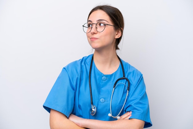 Surgeon doctor woman holding tools isolated on white background making doubts gesture while lifting the shoulders