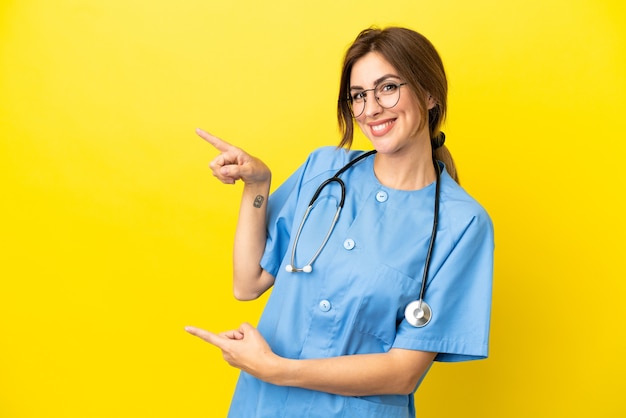 Surgeon doctor woman isolated on yellow background pointing finger to the side and presenting a product