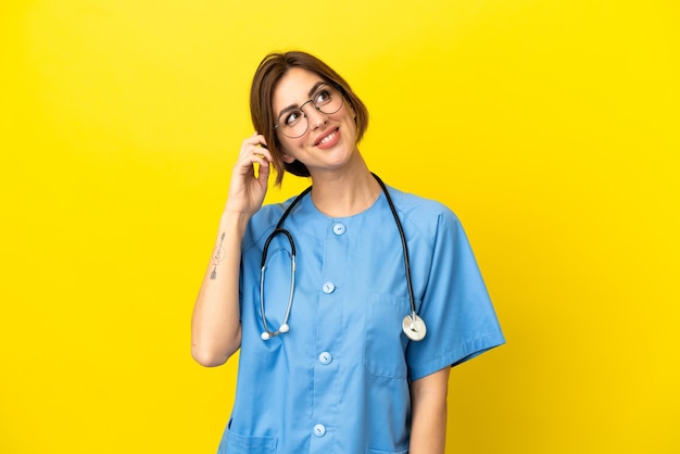 Photo surgeon doctor woman isolated on yellow background thinking an idea