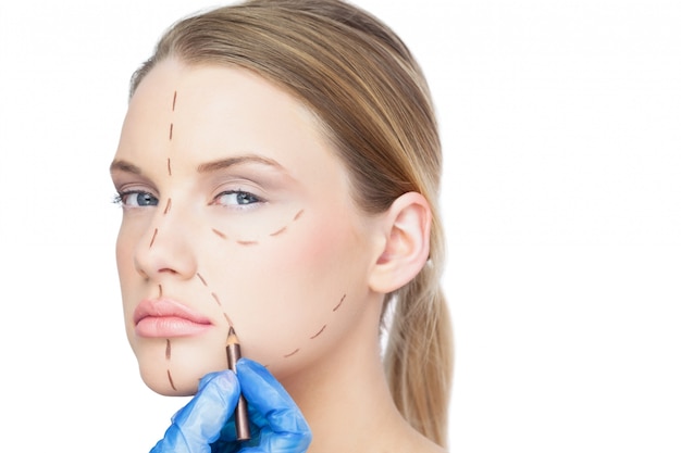 Photo surgeon drawing dotted lines on unsmiling patient