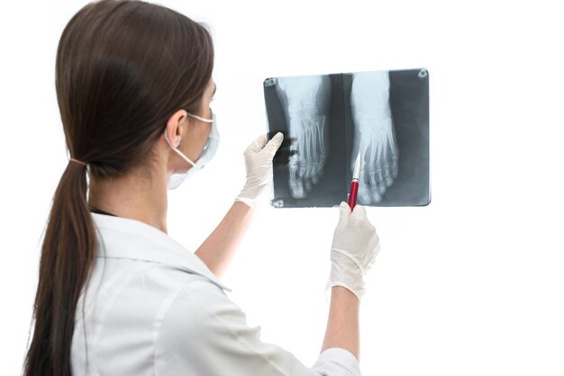 Surgeon examining patient's x-ray on white wall