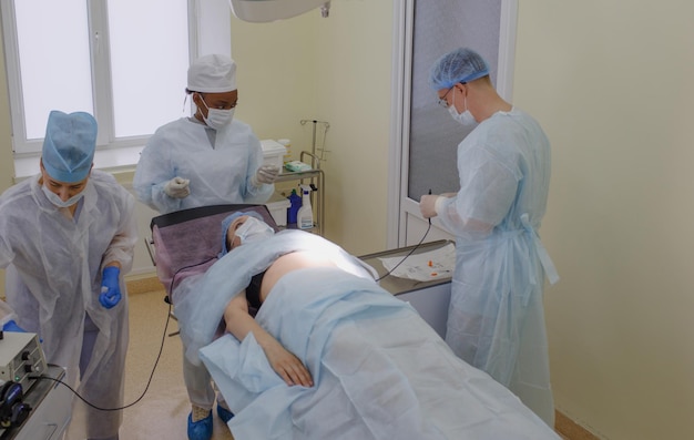 The surgeon and his assistant are preparing for the operation of a patient lying in the operating room