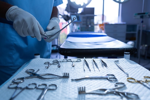 Surgeon holding surgical instrument in operating room of hospital