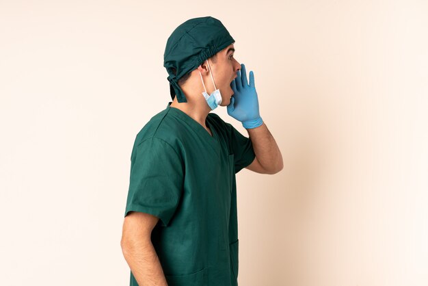 Surgeon man in blue uniform over wall shouting with mouth wide open