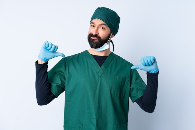 Surgeon man in green uniform over isolated wall proud and self-satisfied