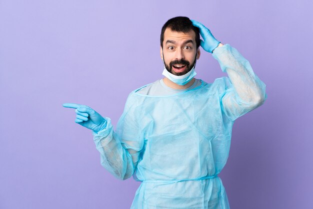 Surgeon man over isolated purple background