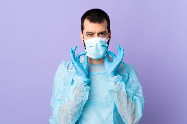 Surgeon man with beard with blue uniform over isolated purple background