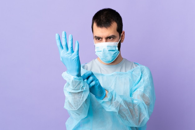 Surgeon man with blue uniform putting on gloves