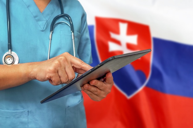Фото Хирург или врач с помощью цифрового планшета на фоне флага словакии
