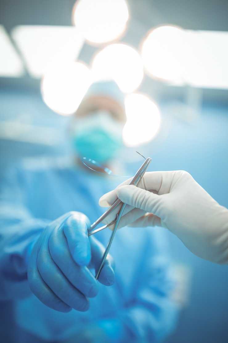 Photo surgeon passing surgical tool to colleague in operation theater