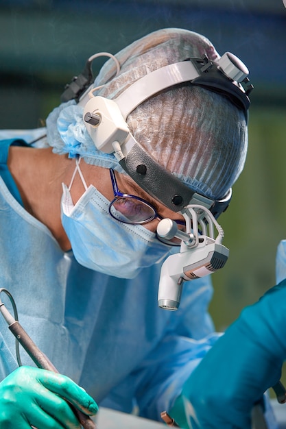 Surgeon performing cosmetic surgery in hospital operating room