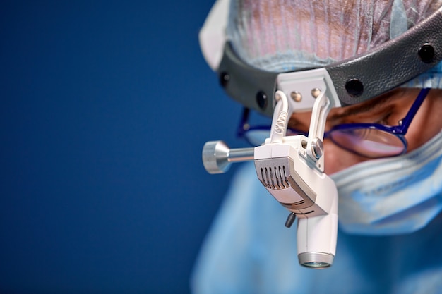 Surgeon performing cosmetic surgery in hospital operating room