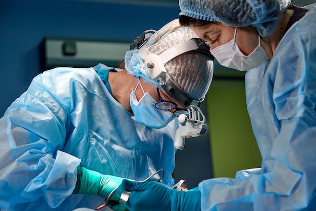 Surgeon performing cosmetic surgery in hospital operating room.