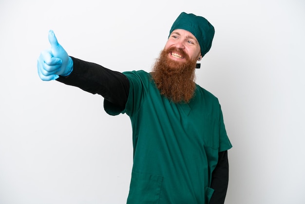 Surgeon redhead man in green uniform isolated on white background giving a thumbs up gesture