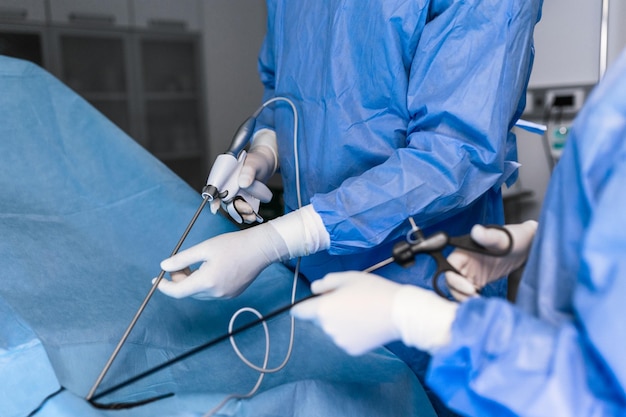 The surgeon's holing the instrument in abdomen of patient The surgeon's doing laparoscopic surgery in the operating room Minimally invasive surgery