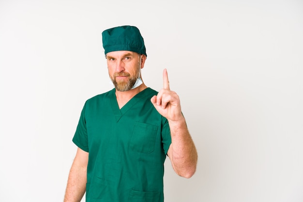 Surgeon senior man on white wall showing number one with finger.