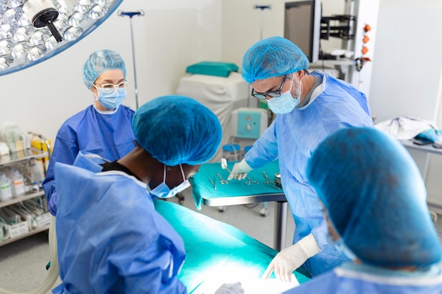 Surgeon team in uniform performs an operation on a patient at a\
cardiac surgery clinic modern medicine a professional team of\
surgeons health
