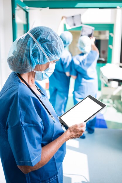 Surgeon using digital tablet in corridor