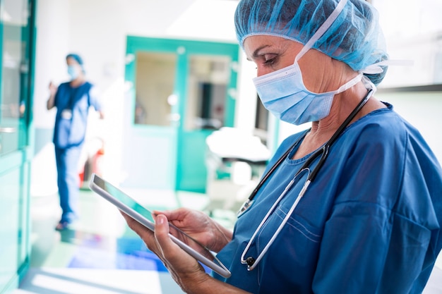 복도에서 디지털 태블릿을 사용 하여 외과 의사
